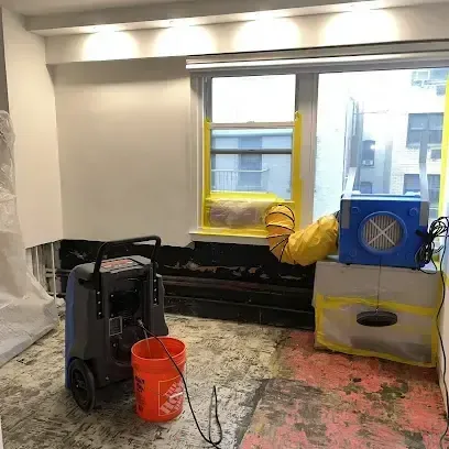 Dehumidifier and air mover drying a room with the flooring removed, equipment an Audubon crew brings